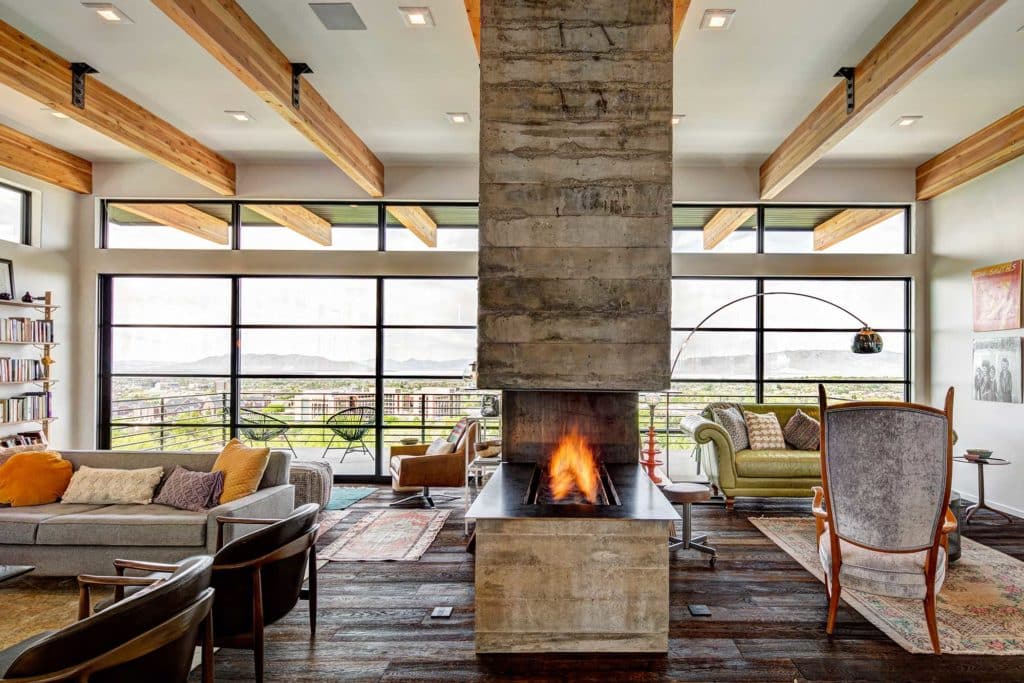 Magnificent living room with freestanding fireplace in front of an entire wall of aluminum windows
