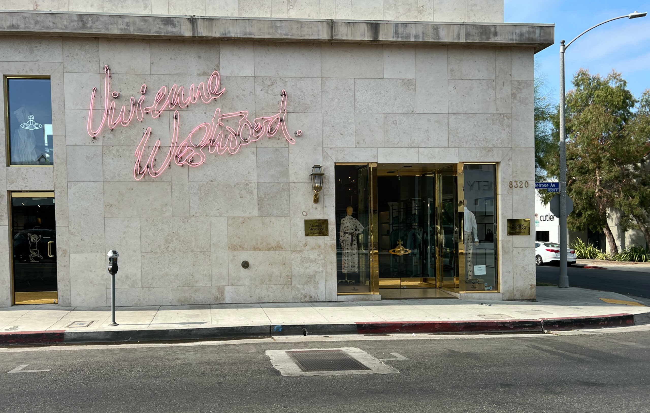 Tinted glass doors surrounded with bronze at the entrance to the Vivienne Westwood storefront on Melrose Avenue