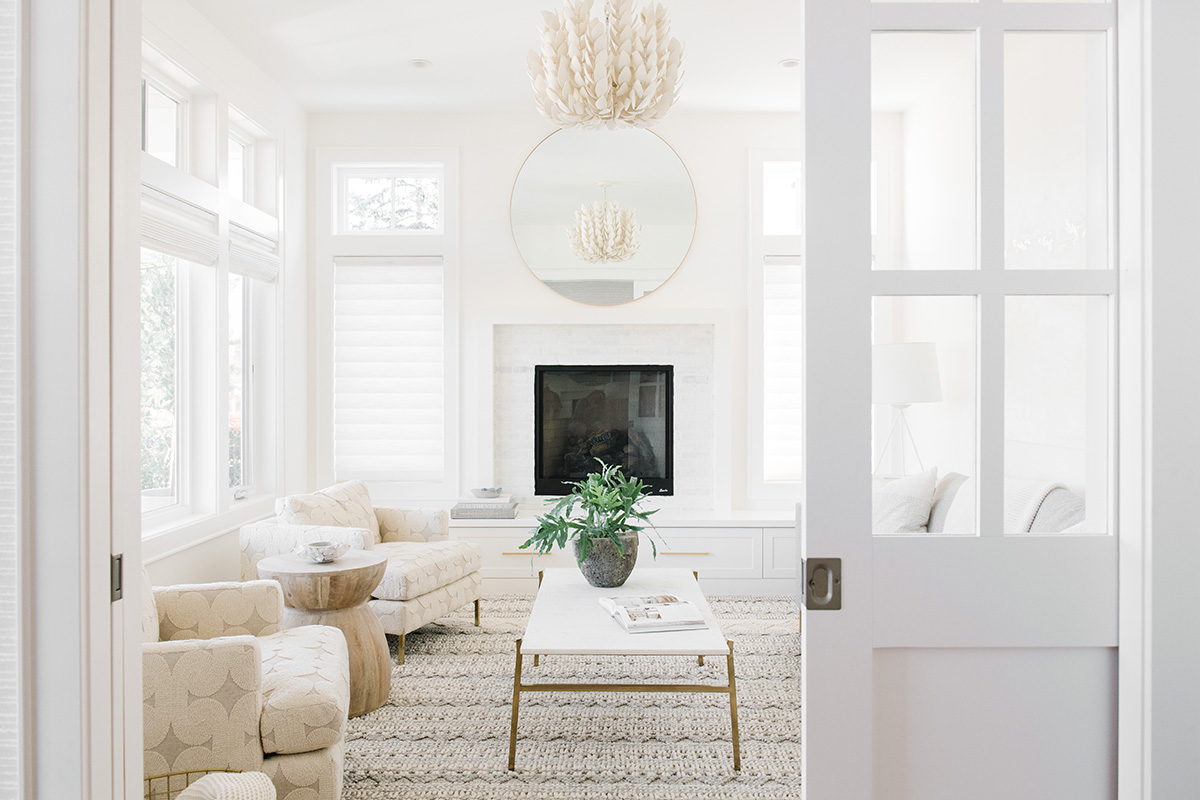White pocket doors open to reveal a beautifully decorated living room decorated in muted colors