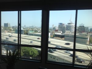 Traffic seen through apartment building soundproof windows overlooking and directly next to the noisy 101 Freeway in LA