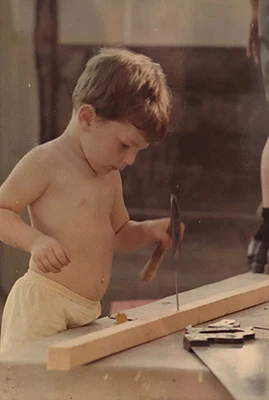 Little Kenny hammering a nail into a piece of wood at about age seven.