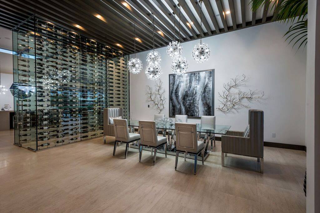 Magnificent dining room area features a glass shelving unit that carries wines of all types.