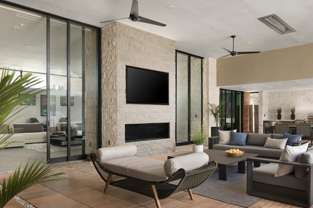 Two sets of Multi-Slide Doors frame a modern brick fireplace to reveal the living room next door.
