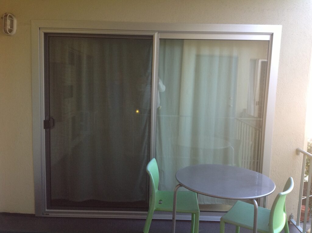 Sliding glass door with a screen, leading to a balcony.