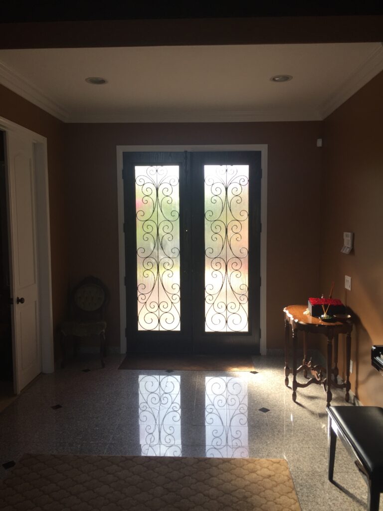 Interior view of a decorative fiberglass door with wrought iron between glass.