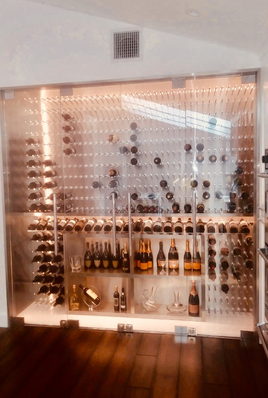 Beautiful glass faced wine cabinet adorns living room wall.