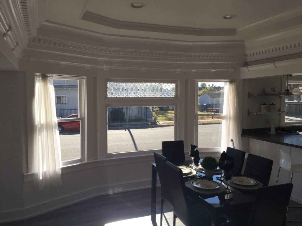 Dining area with large bay windows featuring decorative glass at the top.